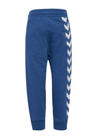 Blaue Jogginghosen aus weichem Stoff, mit einem gerippten Bund, weißen Chevron-Akzenten an den Seiten und enger zulaufendem Bein.