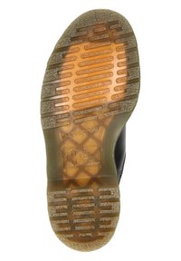 Suela de zapato con banda de rodadura de goma marrón translúcida, surcos horizontales y texto en relieve que incluye "The Original" y un logo de cruz.