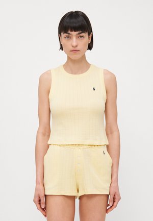 Gul ribbad linne med rund halsringning och en liten logotyp, matchat med shorts som har knappstängning fram och elastisk midja.