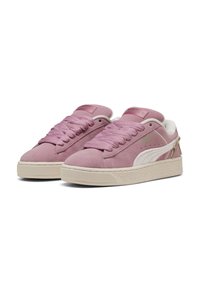 Adidași din suede roz cu sireturi asortate, accente albe și talpă texturată de crem. Prezintă un logo pe limbă și un detaliu decorativ pe lateral.