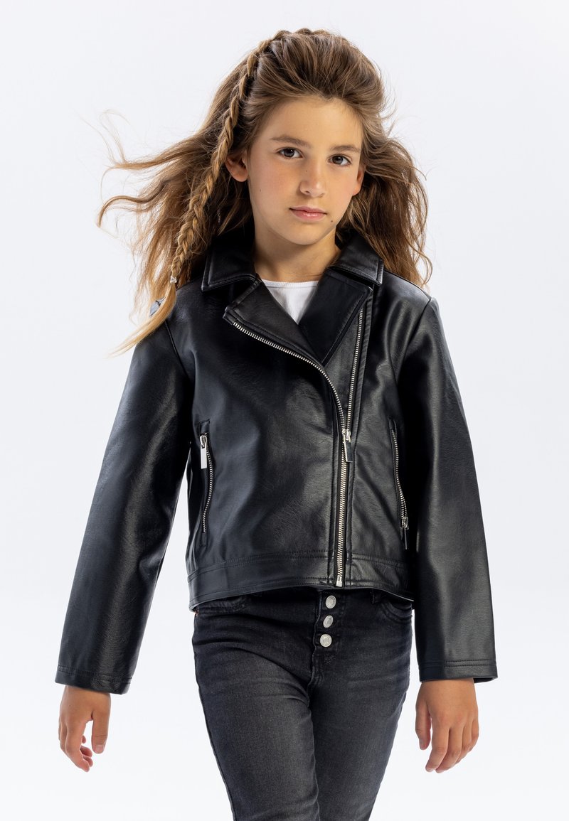 Zwarte faux leren motorjack met een gekartelde kraag, asymmetrische rits en ritszakken; gestyled met zwarte jeans.