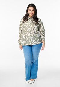 Lightweight floral-patterned shirt in muted green and beige, with a button front and long, gathered sleeves. Paired with light blue jeans.