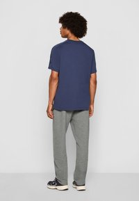 Navyblå bomulds t-shirt med korte ærmer, parret med lysegrå joggebukser. Sættet har en afslappet pasform og minimalistisk design.