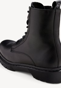Black leather combat boot with a rounded toe, lace-up design, smooth texture, sturdy rubber sole, and a branded heel tab.