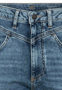 Hoge taille mom fit jeans in middelblauwe denim. Voorzien van zijzakken, koperkleurige stiksels en een metalen knoopsluiting op de taille.