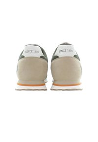 Beige och gröna sneakers med nät- och mockamaterial. Vita hälflikar märkta "SINCE 1890" och vit sula med orange detaljer.