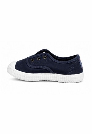 Sneaker slip-on blu navy con suola in gomma bianca e punta, con tre occhielli metallici sul lato per la ventilazione.
