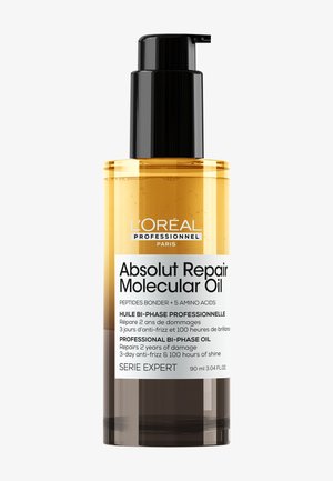 Biphasisk hårolja i en klar flaska med en svart pump. Den bärnstenfärgade vätskan har text som indikerar fördelar för hårreparation och glans. 90 ml storlek.