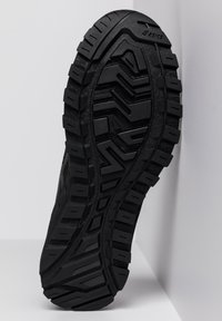 Black hiking shoe sole features a rugged tread pattern, textured finish, and sturdy rubber material for grip and durability.