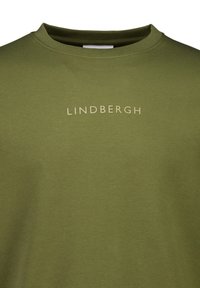 Oliwkowa bawełniana koszulka z okrągłym dekoltem. Posiada subtelne, jasne logo "LINDENBERGH" na przodzie. Gładka tekstura.