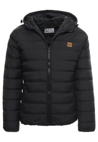 Black puffer jacket with a hood, featuring a zippered front, horizontal quilted pattern, and a small brown logo patch on the chest.