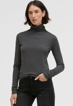 Graues Langarm-Turtleneck-Oberteil aus weichem Stoff, mit enganliegendem Design und gerippter Textur, kombiniert mit schwarzen Jeans.