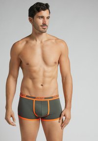 Zielone oliwkowe bokserki z pomarańczowymi akcentami, z elastycznym pasem z logo "HUMAN" i dopasowanym krojem. Miękka, elastyczna tkanina.