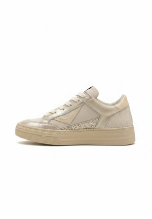 Beige lage sneaker met textuur- en gladde panelen, veters aan de voorkant en dikke rubberen zool op een witte achtergrond.