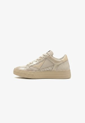 Sneaker beige bassa con pannelli testurizzati e lisci, chiusura frontale con lacci e suola spessa in gomma su sfondo bianco.