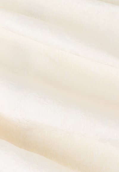 Tessuto in crema e beige chiaro con una trama e un motivo sottile. I ripiegamenti drappeggiati creano profondità e variazioni nei toni di colore.
