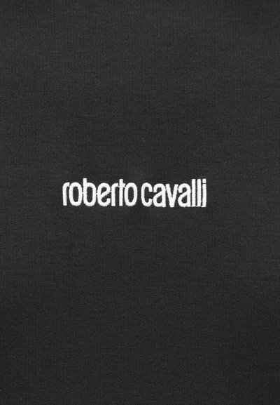 Melns audums ar baltu izšūtu "roberto cavalli" logo, kas ir centrēts uz tā.