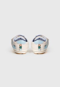 Καμβά παπούτσια σε ανοιχτό κρεμ με μπλε λεπτομέρειες και διακοσμητικά μοτίβα. Διαθέτουν λουριά με αυτοκόλλητο βέλκρο και υφασμένη ελαστική σόλα για καλύτερη πρόσφυση.