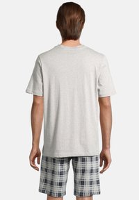 T-shirt gris à manches courtes, en tissu doux, accompagné de shorts à carreaux bleu marine et gris clair avec une coupe décontractée et une taille élastique.