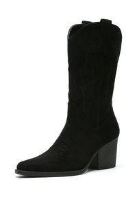 Bota vaquera de ante negro con punta afilada, tacón block de altura media y cortes decorativos en el caña. Superficie texturizada, diseño elegante.