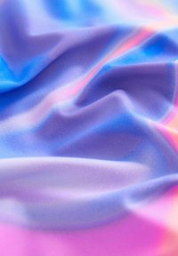 Tessuto colorato e fluido con una superficie liscia che presenta tonalità di blu, viola e rosa in un modello a gradiente. Visibili onde e pieghe dettagliate.