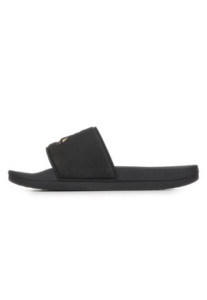 Sandalo nero tipo slide con fascia larga e suola piatta texturizzata, mostrato di profilo su sfondo bianco.