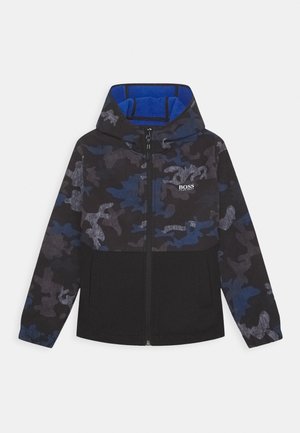 Chaqueta con capucha que presenta un patrón de camuflaje negro y azul marino, hecha de material polar, con cierre de cremallera y bolsillos frontales.
