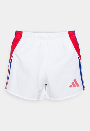 Bijele atletske kratke hlače s crvenim i plavim bočnim panelima, elastičnim pojasom i ružičastim Adidas logom na donjem dijelu prednje strane. Glatka tekstura tkanine.