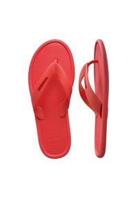 Paire de tongs rouges avec semelles texturées et larges brides en tissu, l'une vue de dessus et l'autre de côté sur fond blanc.