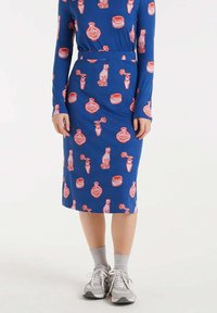 Vestido azul de manga larga con una silueta ajustada, que presenta un patrón rojo y rosa de gatos y jarrones. La tela tiene una textura suave.