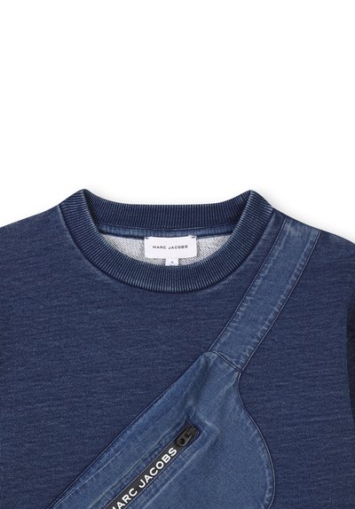 Sweatshirt bleu à col rond avec des accents en denim. Il comprend une poche en denim diagonale avec une fermeture éclair et un logo, un tissu texturé et un col côtelé.