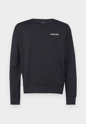 Sweat-shirt noir en tissu doux, avec des manches longues, un col rond et un logo blanc "Club1990" sur la poitrine. Design simple.