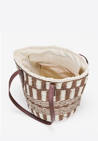 Borsa a tracolla intrecciata in marrone e crema con un motivo a quadri. Presenta un bordo intrecciato e manici in pelle marrone. Interno foderato con tasca.
