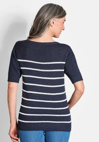 Navy Pullover mit weißen horizontalen Streifen, kurzen Ärmeln und einem Bootsausschnitt. Die Rückseite zeigt eine lockere Passform und Rippendetails am Saum.