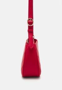 Sac à main synthétique rouge avec un design structuré, des détails embossés, et une bandoulière ajustable dotée d'une boucle dorée.