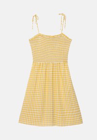 Žluté kostkované šaty s nařaseným korzetem, tenkými nastavovacími ramínky a splývavou sukní. Tkanina má lehký, strukturovaný vzhled.