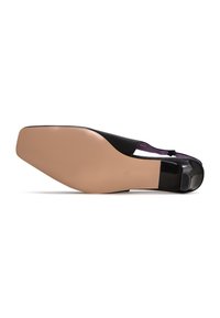 Scarpa piatta nera in pelle con suola beige, caratterizzata da un design elegante e lati con ritagli. Texture liscia con dettagli interni viola.