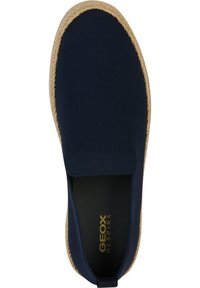 Zapato deslizante texturizado azul con punta redondeada, media suela de yute y suela de goma. Presenta un branding discreto en la plantilla.