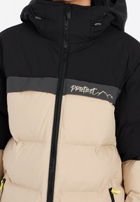 Veste rembourrée avec une capuche noire, un corps beige et des accents gris foncé. Comprend une fermeture éclair à l'avant et un logo sur la poitrine.