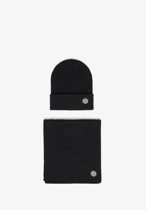 Svart strikket lue og matchende skjerfsett, hver med en liten hvit geometrisk logo på hvit bakgrunn.