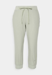 Pantalon décontracté vert clair avec taille élastique et cordon de serrage, chevilles retournées et poches latérales.