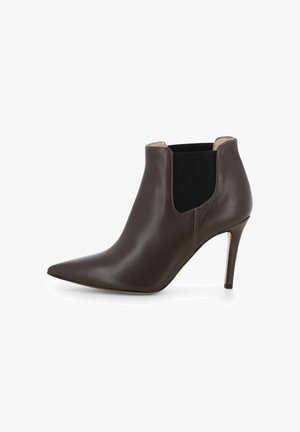 Bottine en cuir marron avec un bout pointu, des panneaux latéraux élastiques et un talon aiguille fin. Texture lisse avec des détails de couture minimaux.