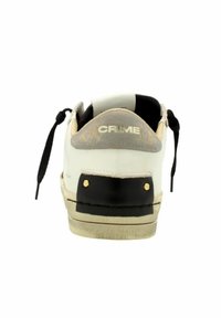 Sneaker met een bovenwerk van wit leer, een zwarte rubberen hak, grijze accenten en contrasterende gouden hardware; beschikt over een gestructureerde zool en zwarte veters.