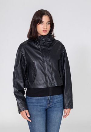 Schwarze Lederjacke in cropped Form mit hohem Kragen, durchgehendem Reißverschluss und zwei seitlichen Taschen. Glatte Textur mit minimalen Hardware-Details.