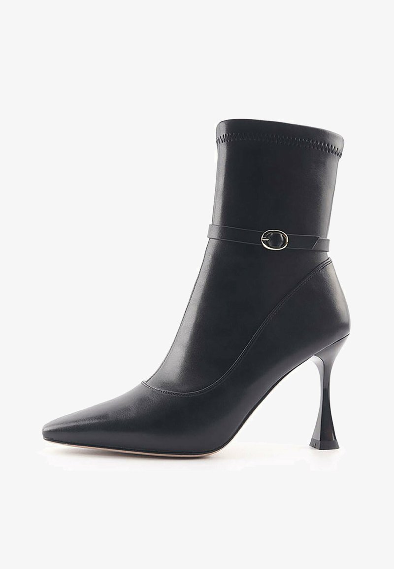 Black leather ankle boot with a pointed toe and tapered heel. Features a fitted shaft, decorative strap, and contrasting stitching.