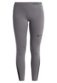 Szare legginsy Nike Pro z czarnymi panelami bocznymi, logo Nike na udzie oraz napis "NIKE PRO" na pasku, widok z przodu.
