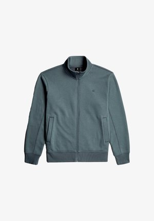 Męska kurtka zapinana na suwak w ciemnozielonym kolorze. Wykonana z miękkiego materiału z wysokim kołnierzem. Posiada boczne kieszenie i kontrastowe przeszycia.