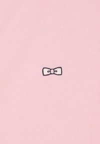 Tissu tricoté rose avec un petit nœud brodé en blanc et contours noirs, centré et texturé avec un motif côtelé.