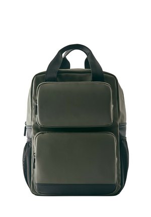 Sac à dos vert foncé avec deux poches zippées à l'avant, poignées noires et supports latéraux en filet pour bouteilles d'eau sur fond blanc.