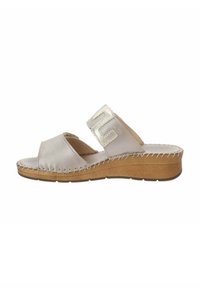 Sandal in un piume beige chiaro con accenti metallici, design open toe, dettagli cuciti lungo la suola e un tacco moderato in legno.